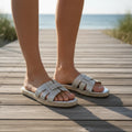 Sandalias de yute con pedrería mujer luciendo elegancia y comodidad en un entorno veraniego junto al mar.