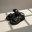 Plataforma Eleva Sandalia negra con diseño moderno y cómodo, ideal para uso diario y elegancia.